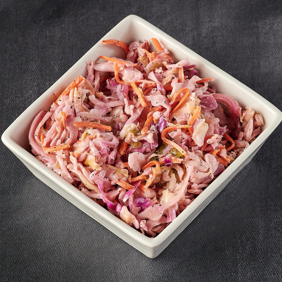 Hot Chicks House of Chicken's coleslaw, a side dish with shredded cabbage, carrots, and dressing.